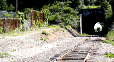 Train tracks going through a tunnel Description automatically generated with medium confidence